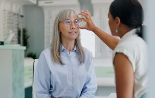 femme de 50 ans chez l'opticien qui essaie une paire de lunette