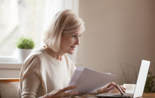 femme regadant ordinateur avec documents