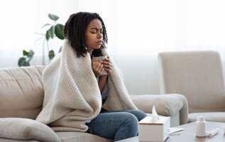 femme malade avec couverture, tasse et mouchoir