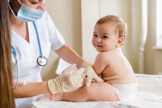 Médecin qui vaccine un bébé