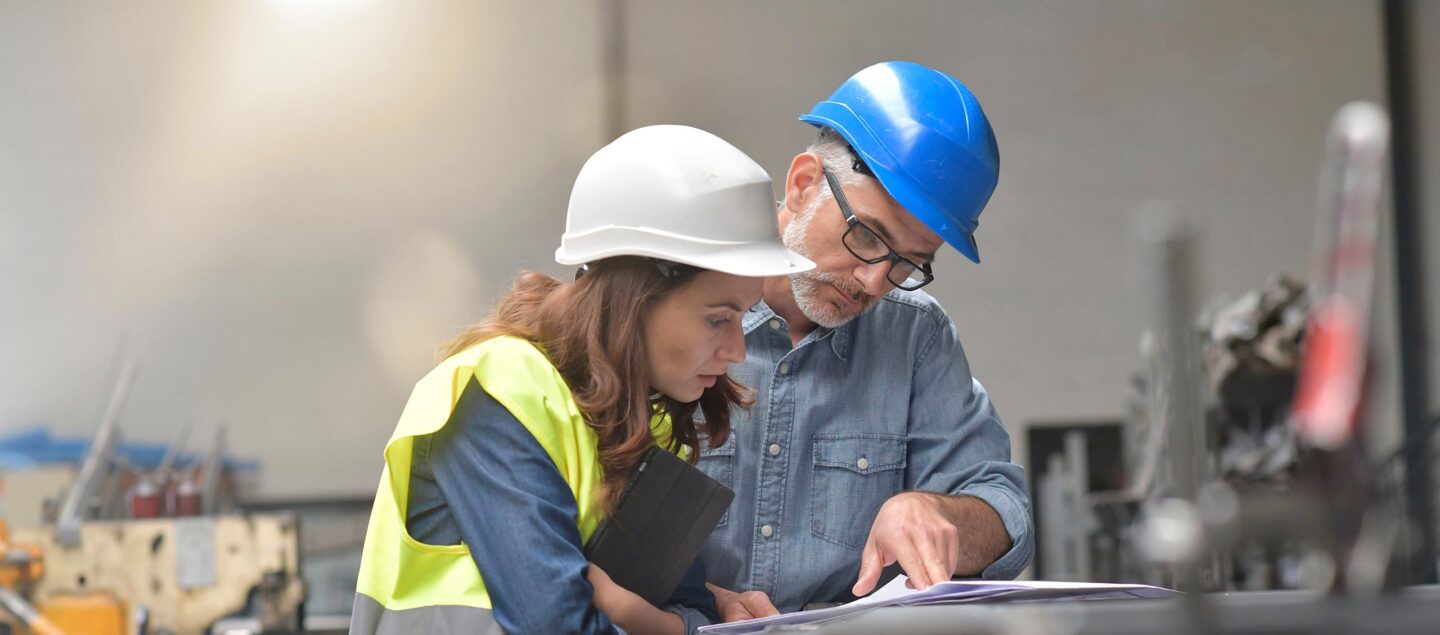 deux collègues qui travaillent dans une usine avec des casques