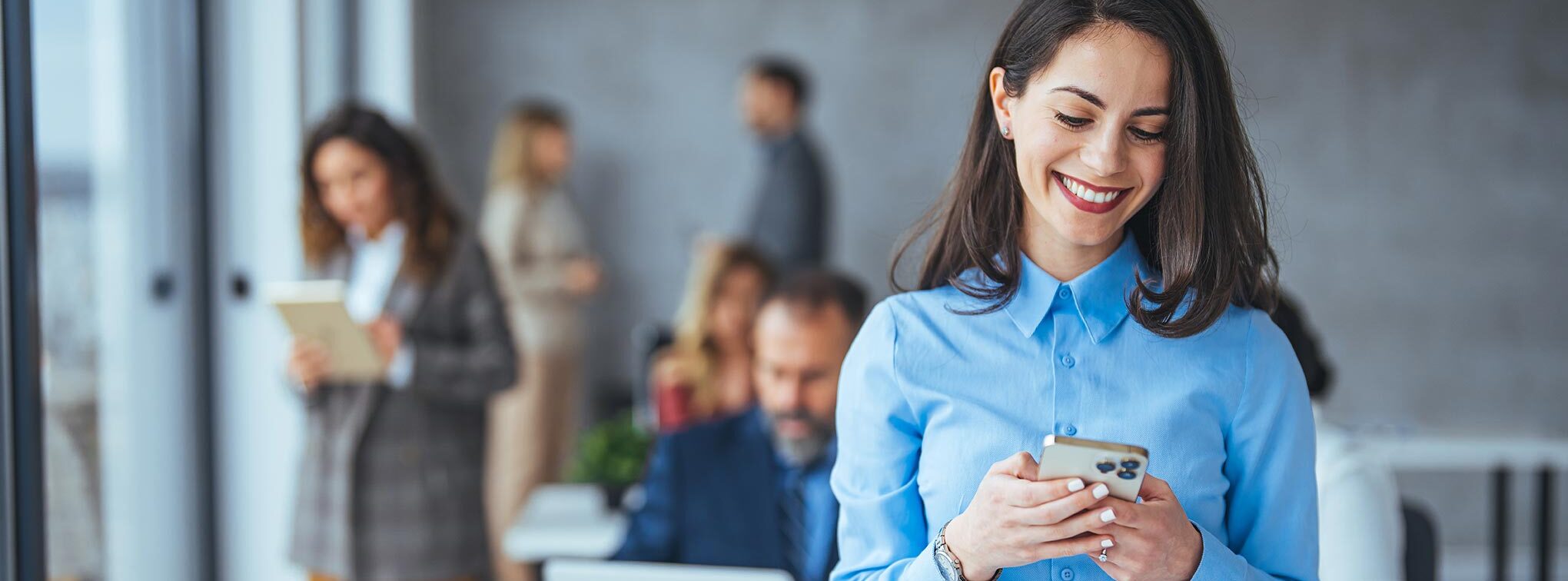 femme qui regarde son telephone en souriant