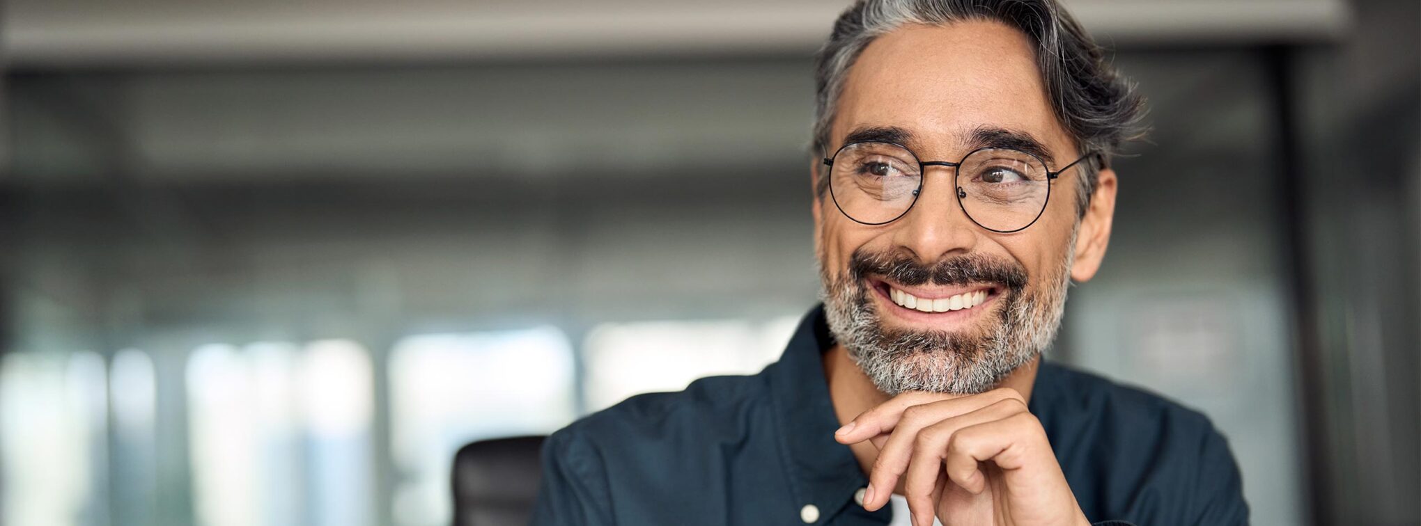 homme à lunette qui sourit devant ordinateur