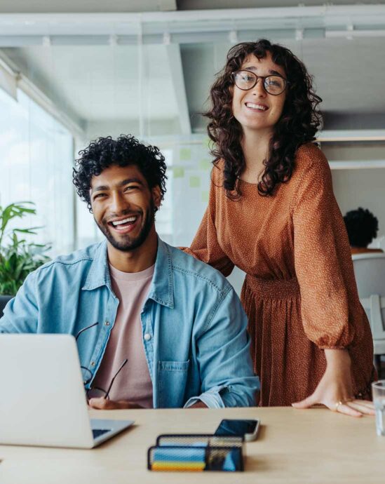 deux collegues qui sourit à leur bureau