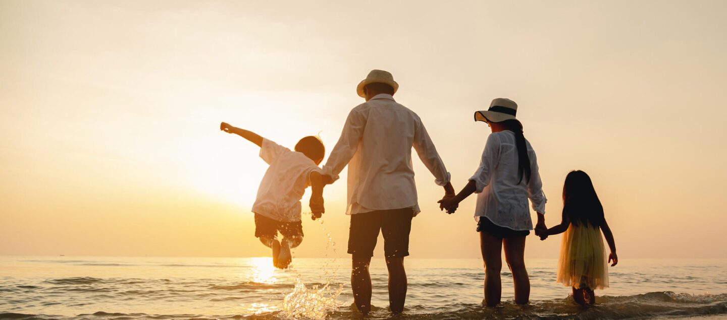 famille à la plage qui saute dans l'eau