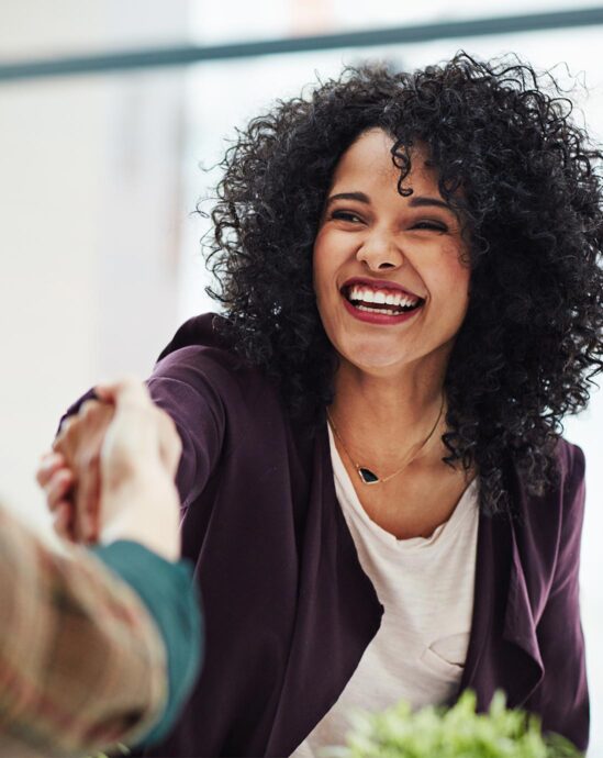 femme qui sert une main en souriant