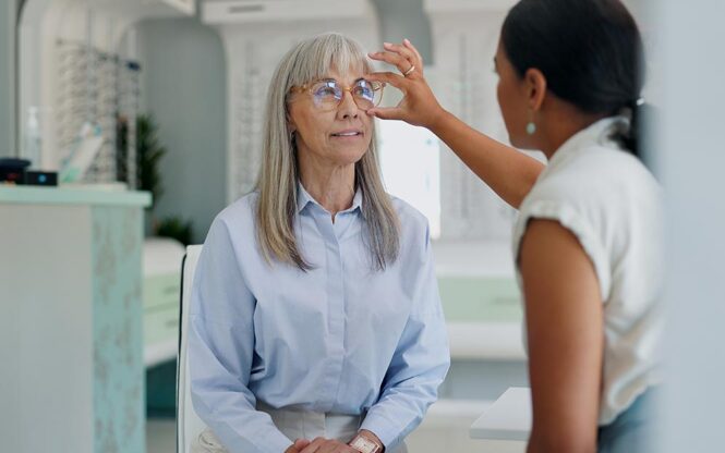 femme de 50 ans chez l'opticien qui essaie une paire de lunette