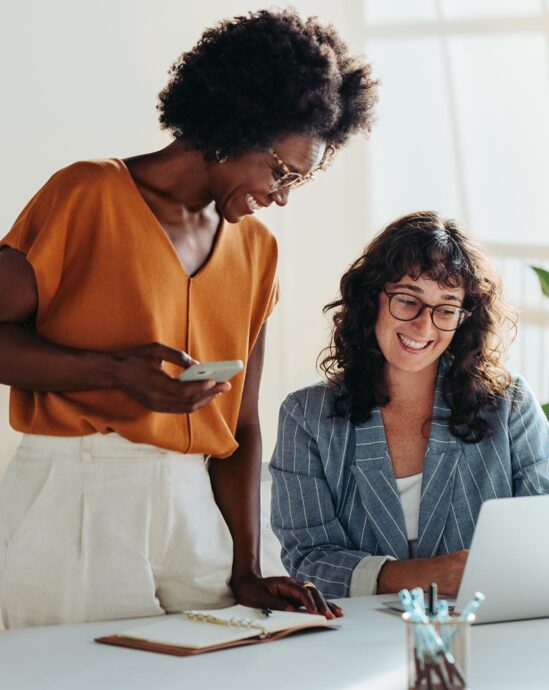 deux femmes qui sourient au bureau