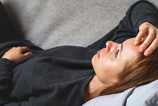 une femme allongée sur son canapé en état de stress post traumatique