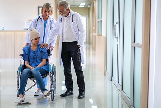 deux médecins avec une patiente en plein traitement de son cancer