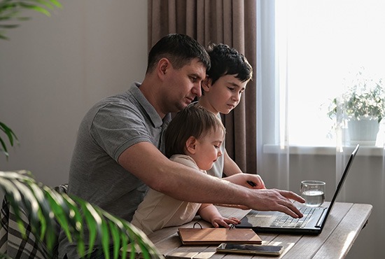 un TNS travaillant chez lui, avec sa famille autour de lui.