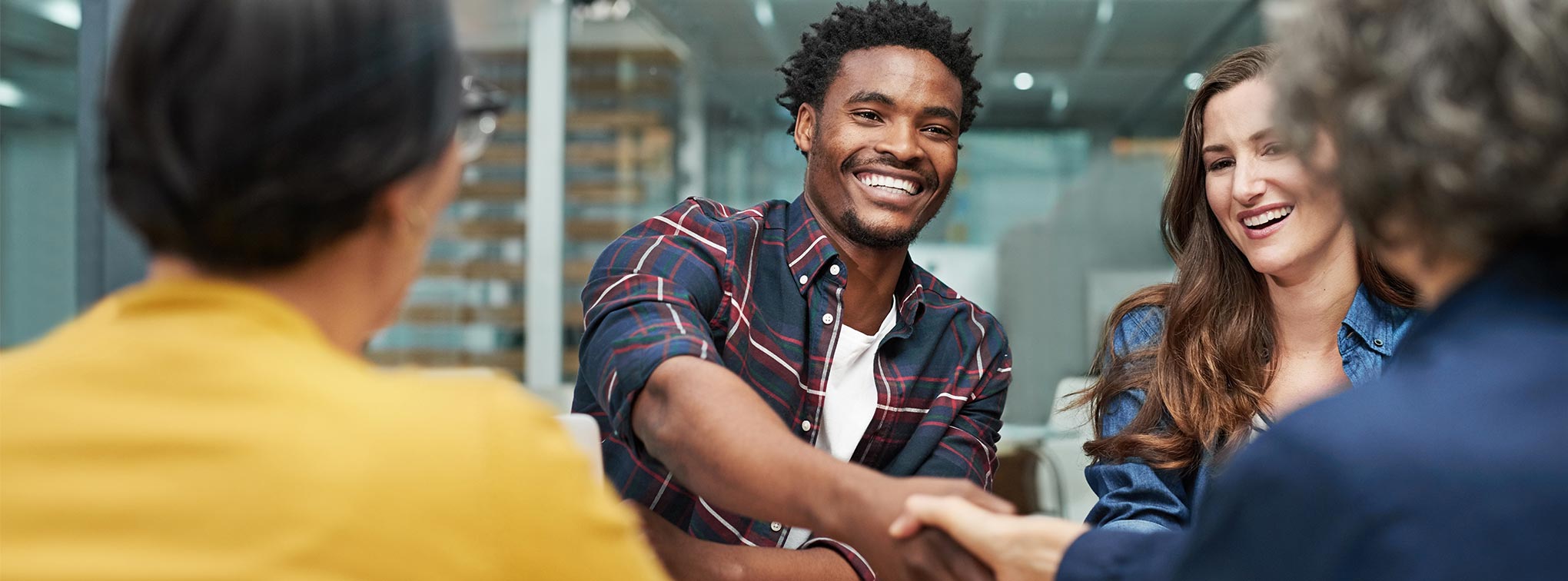 homme souriant qui sert la main lors d'un entretien