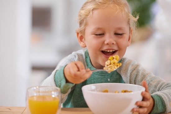 un jeune enfant mangeant des aliments ultra- transformés