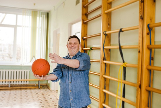 Un homme atteint de la trisomie 21 touchant un ballon de basket