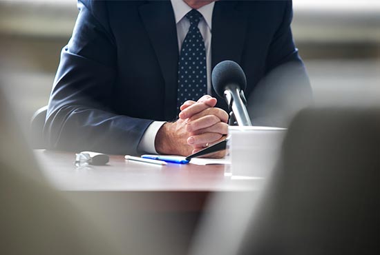 personne devant un micro à un communique de presse